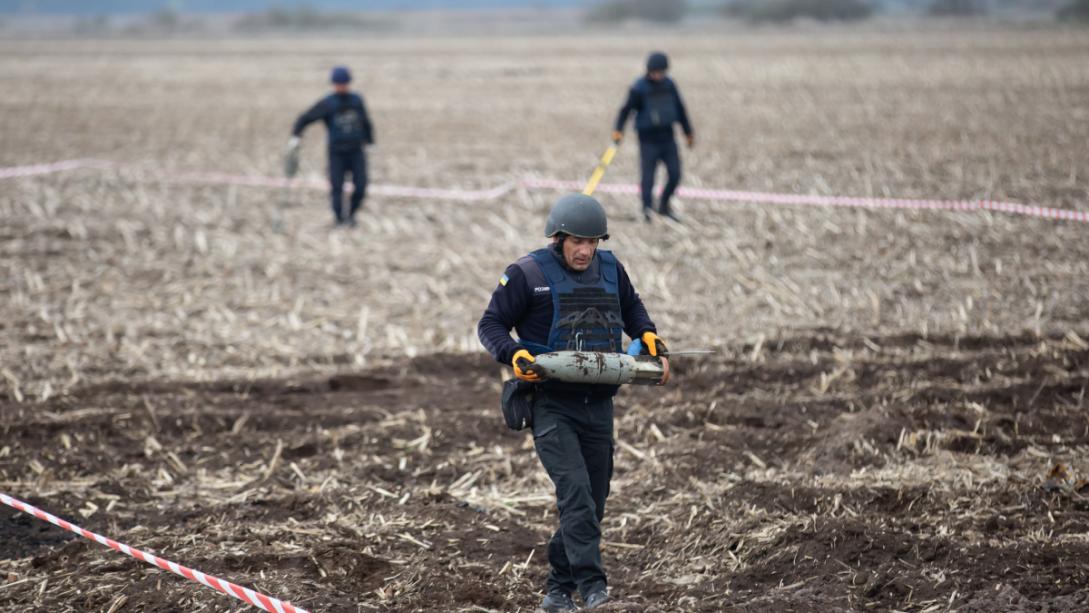 A landmine clearance team at work in a field.